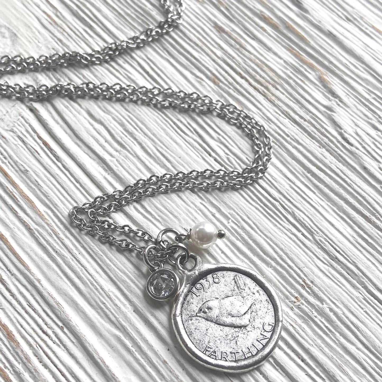 Necklace with a coin pendant on a textured surface