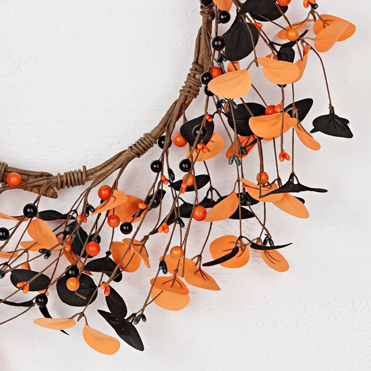 Decorative wreath with orange and black leaves on a white background