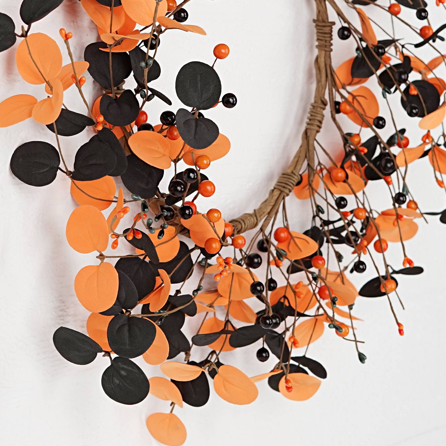 Decorative wreath with orange and black leaves on a white background