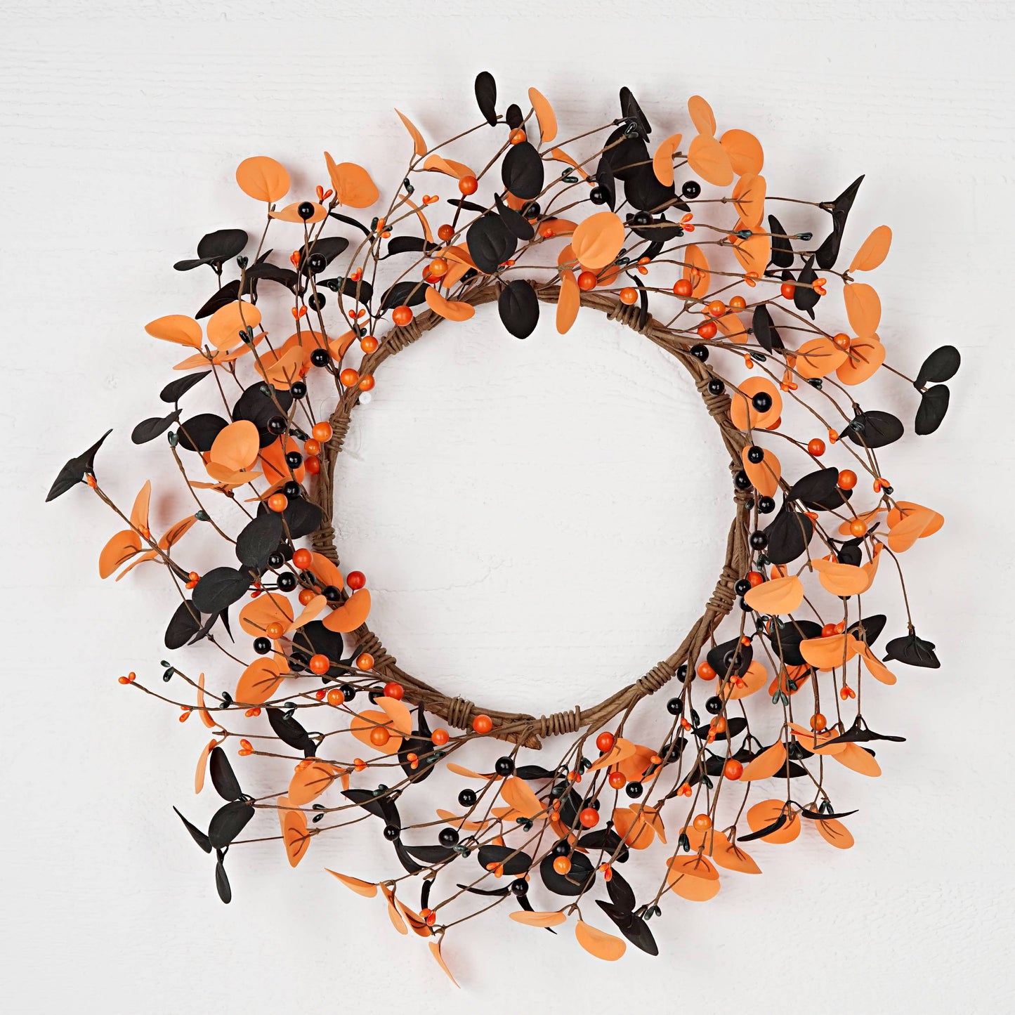 Decorative wreath with orange and black leaves on a white background