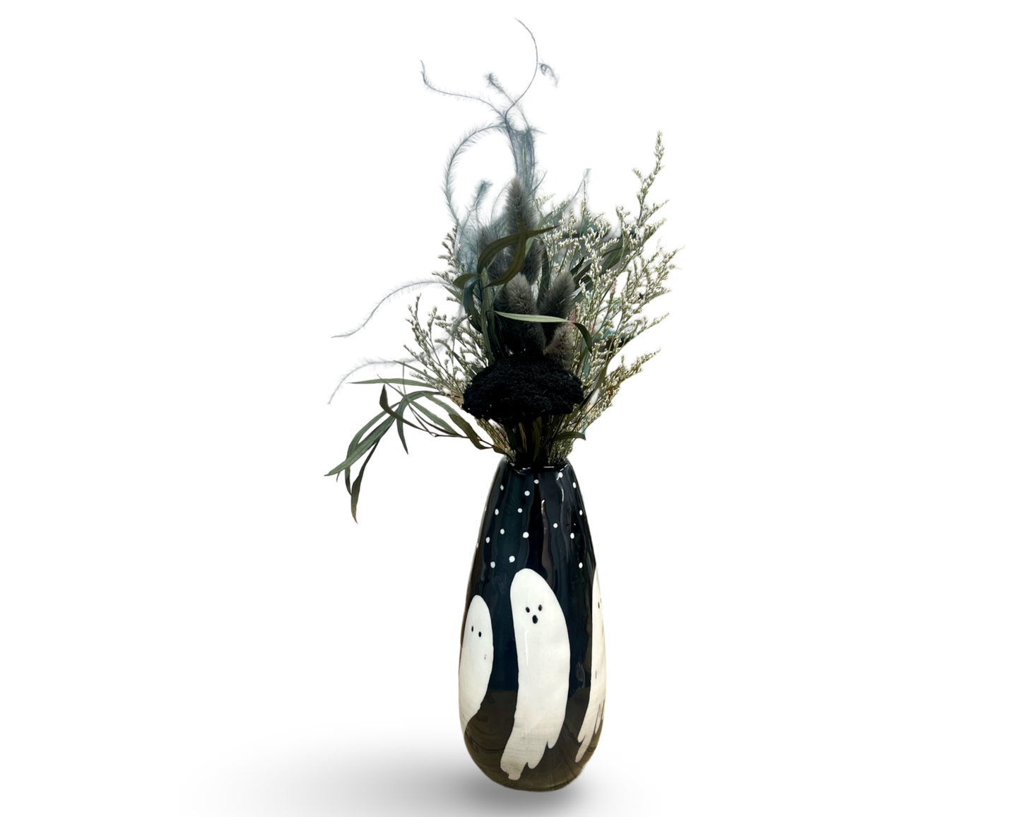 A hand painted ceramic ghost-themed vase with a black and white color scheme, featuring ghosts wrapped around its surface, and a tapered shape. It includes a spooky bundle of dried stems.