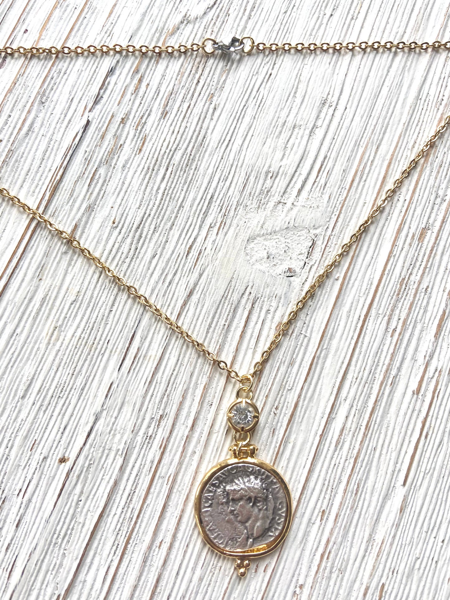 Necklace with a coin pendant on a wooden surface