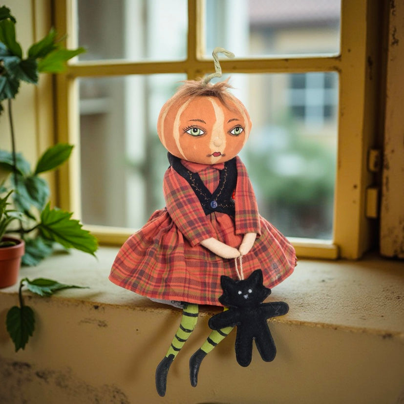 Halloween doll with plaid dress and black cat toy on a windowsill