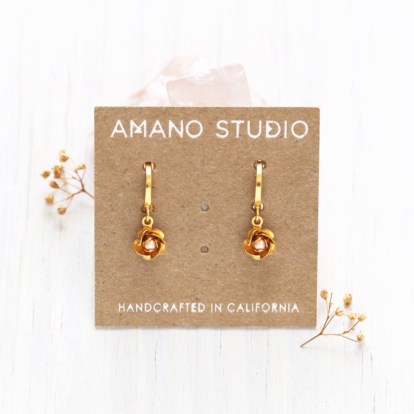 gold rose drop earrings on brown card