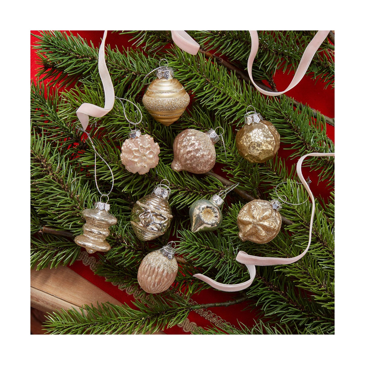 Decorative Christmas ornaments on a branch with a red background
