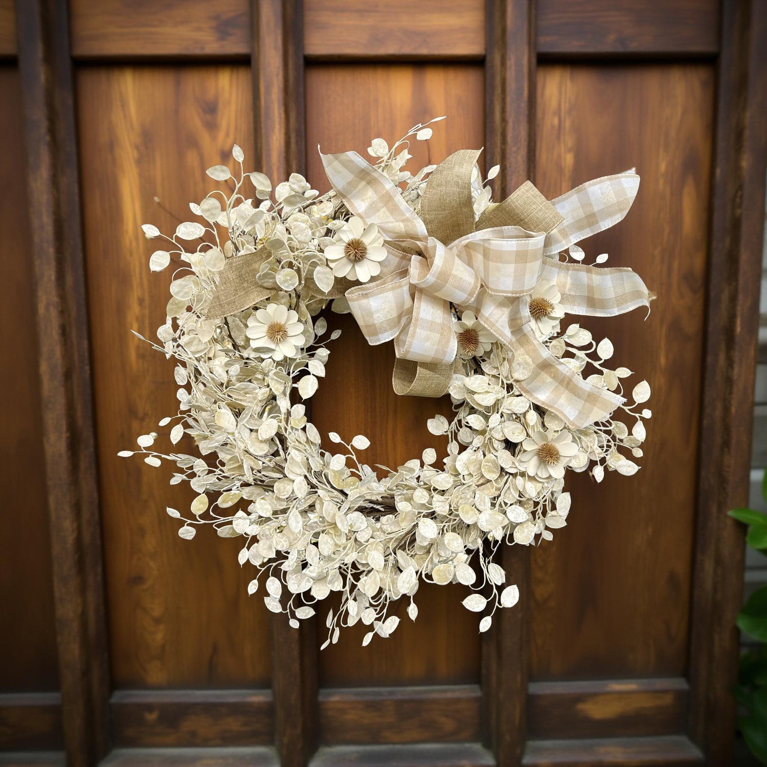 Decorative wreath with a plaid bow on a wooden door