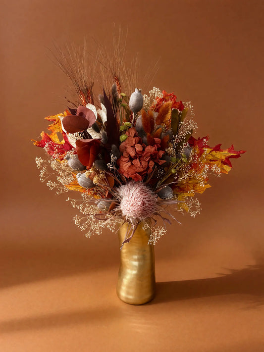 Autumn dried flowers in gold designer vase