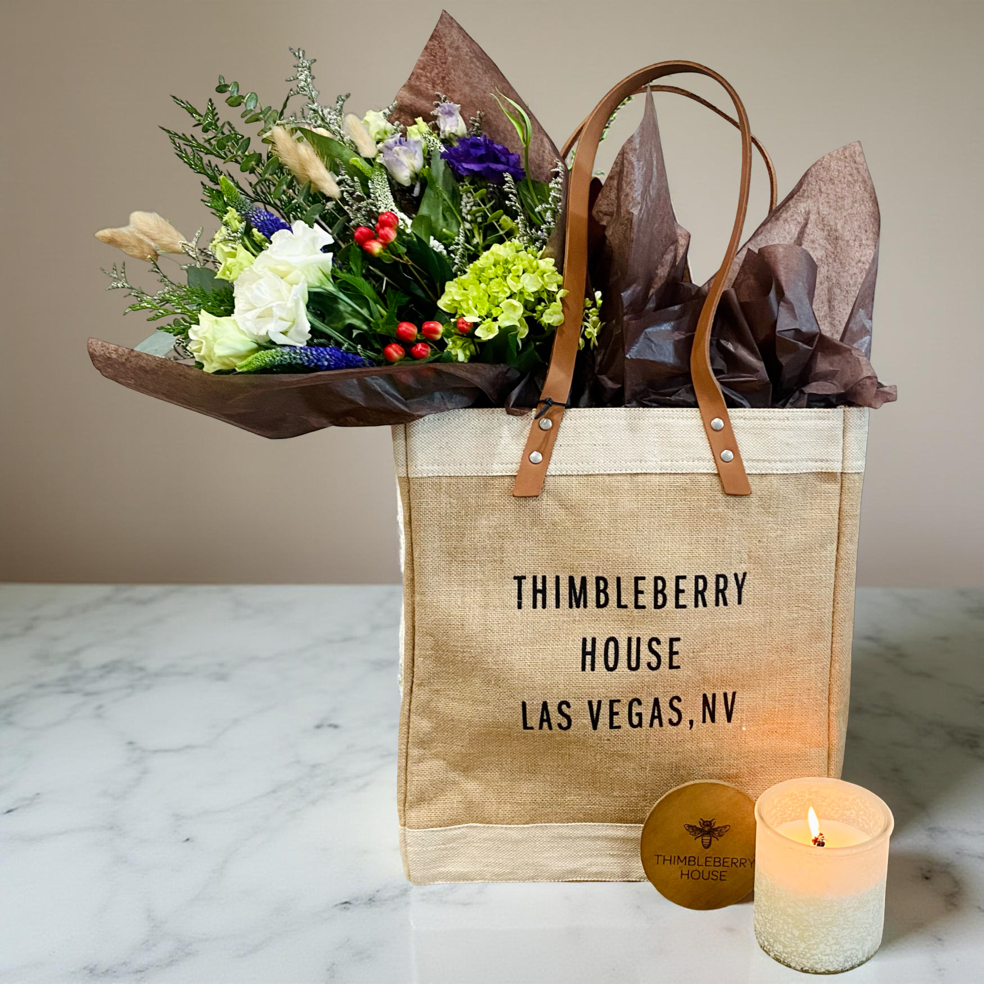 market bag filled with flower bouquet and candle 