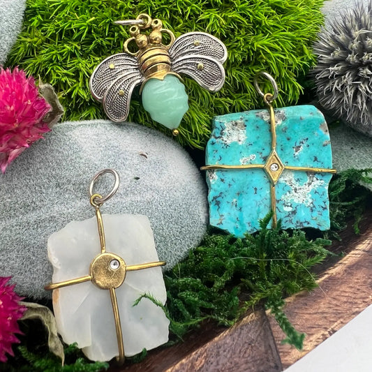 collection of retired waxing poetic charms including the bee brave pendant, turquoise pendant, and moonstone pendant