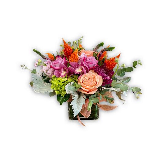 Cheerful Mix fresh flower arrangement with purple, pink, peach, and orange blooms accented by bright green foliage in low and lush style