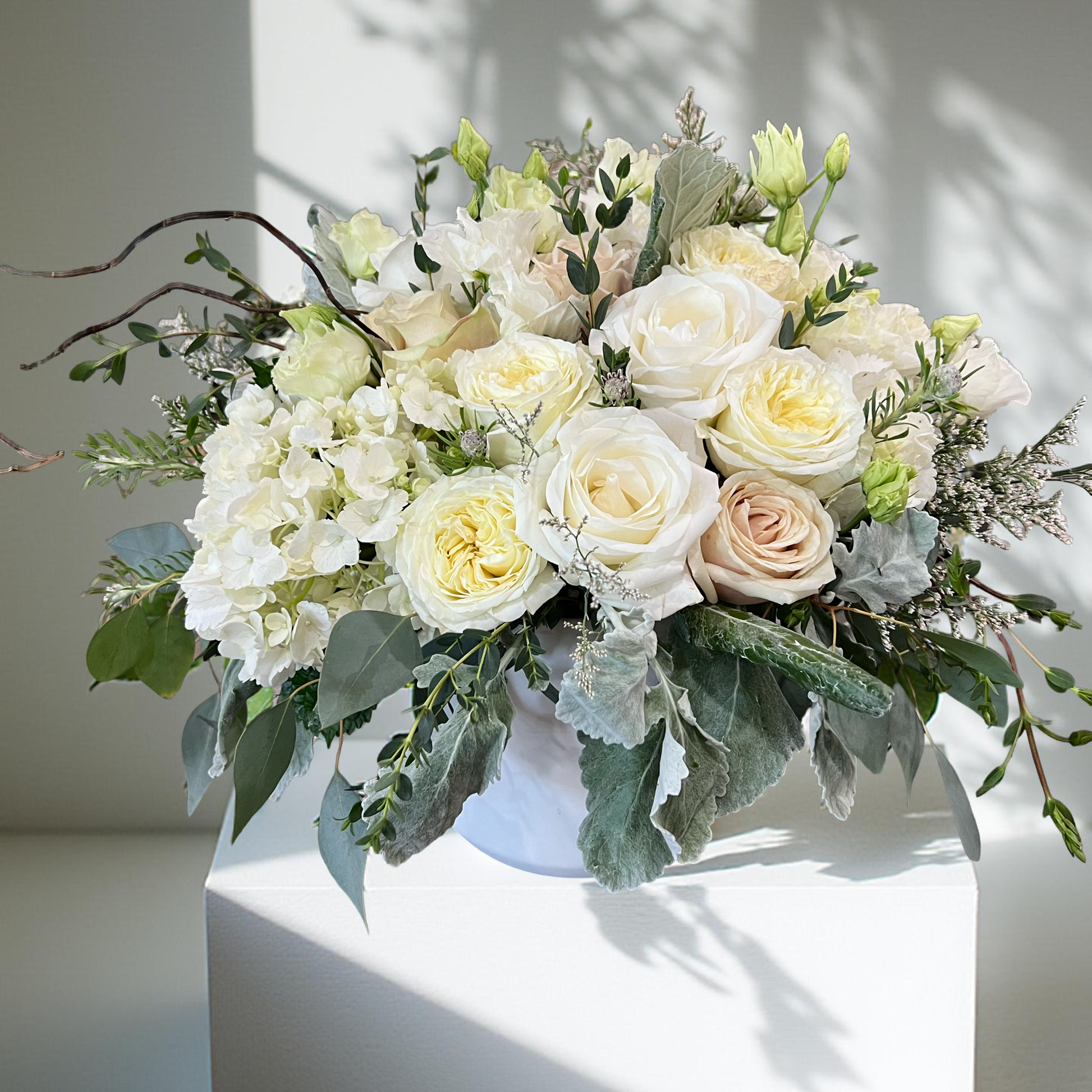 all white and cream flowers in a white vase 