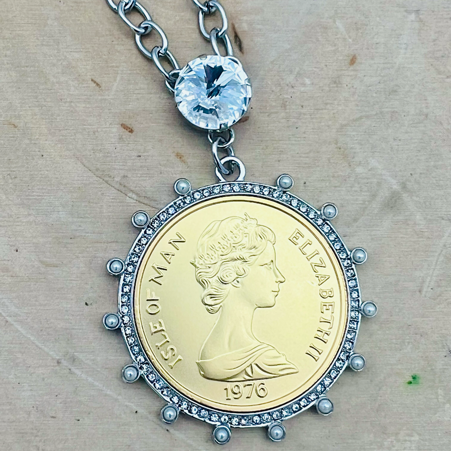 Closeup up of statement Queen Elizabeth II coin pendant with large swarovski crystal
