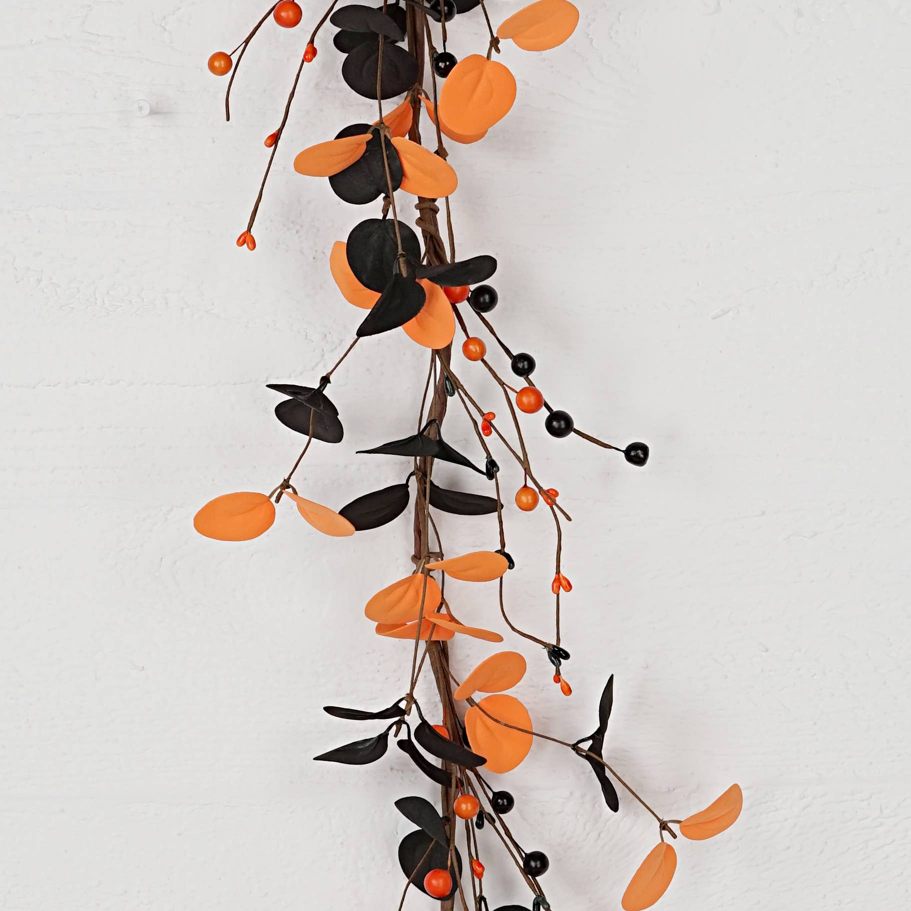 Decorative garland with orange and black leaves on a white background