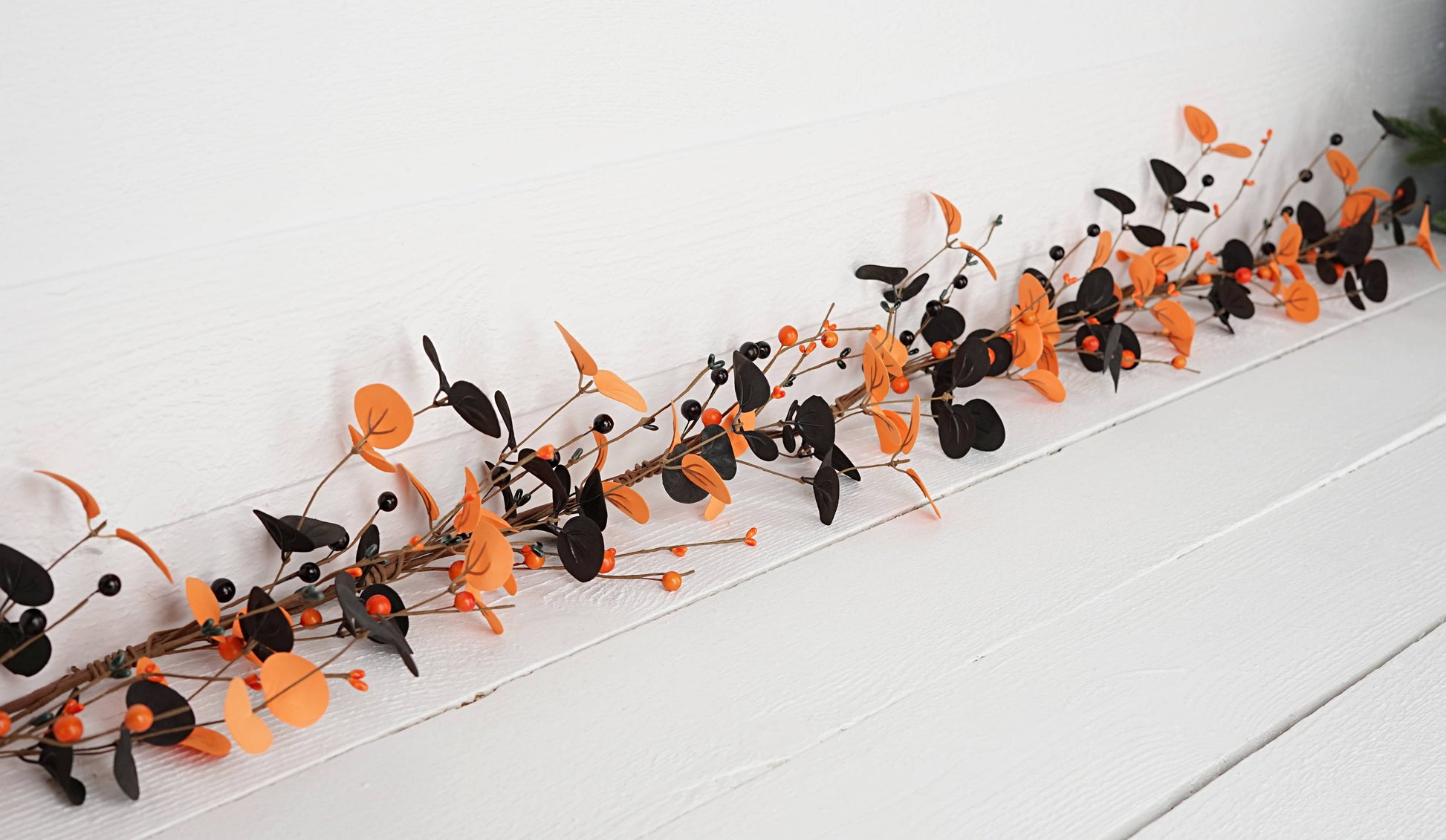 Decorative Halloween garland with black and orange birds on a white surface