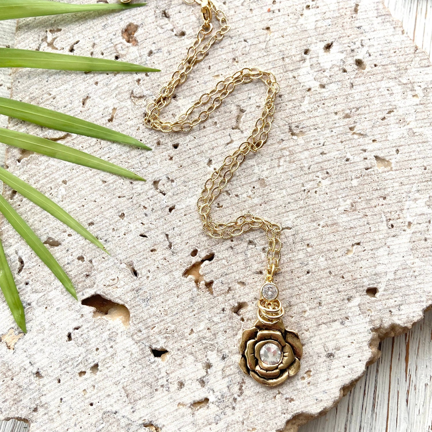 gold and crystal flower pendant on a gold chain