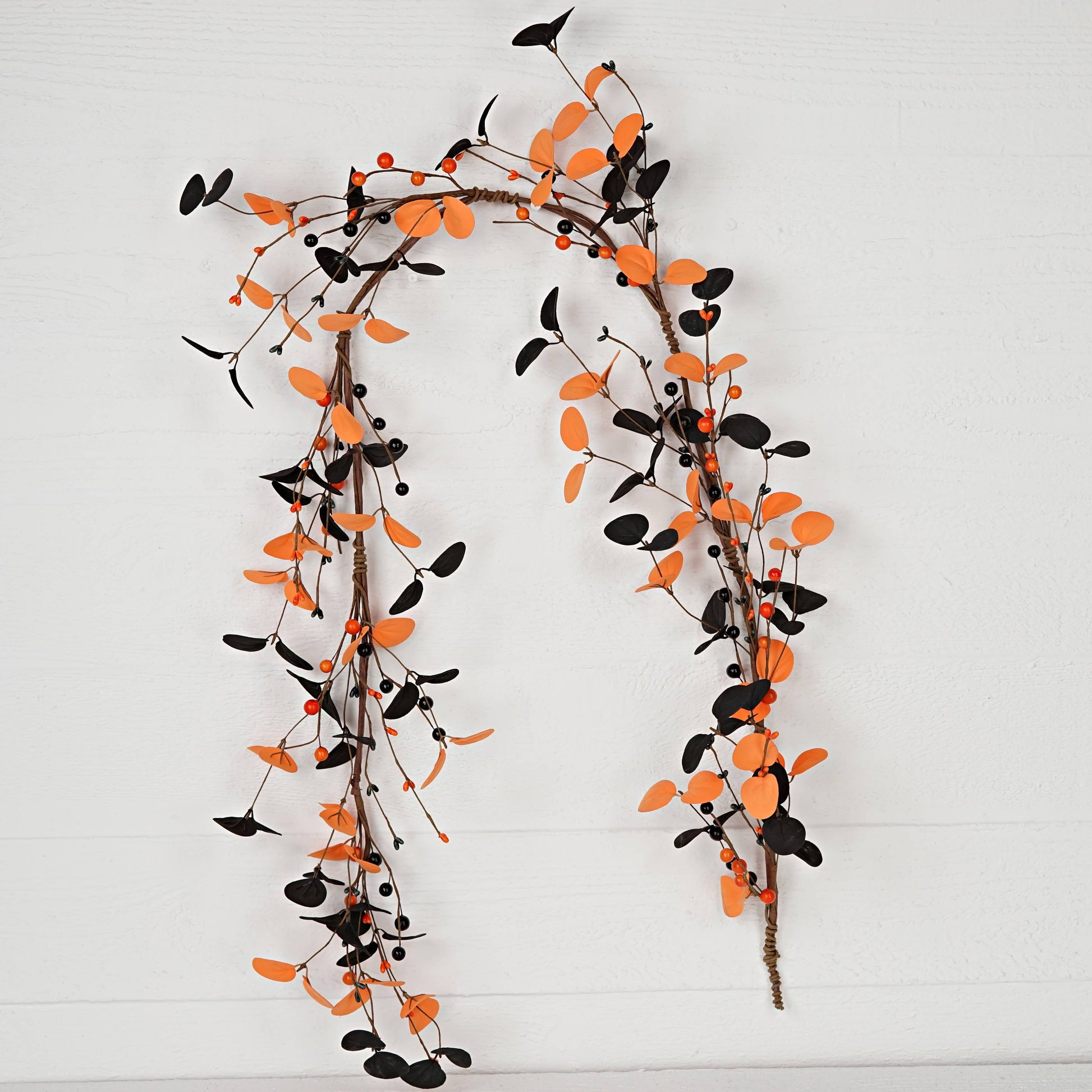 Decorative garland with orange and black leaves on a white background