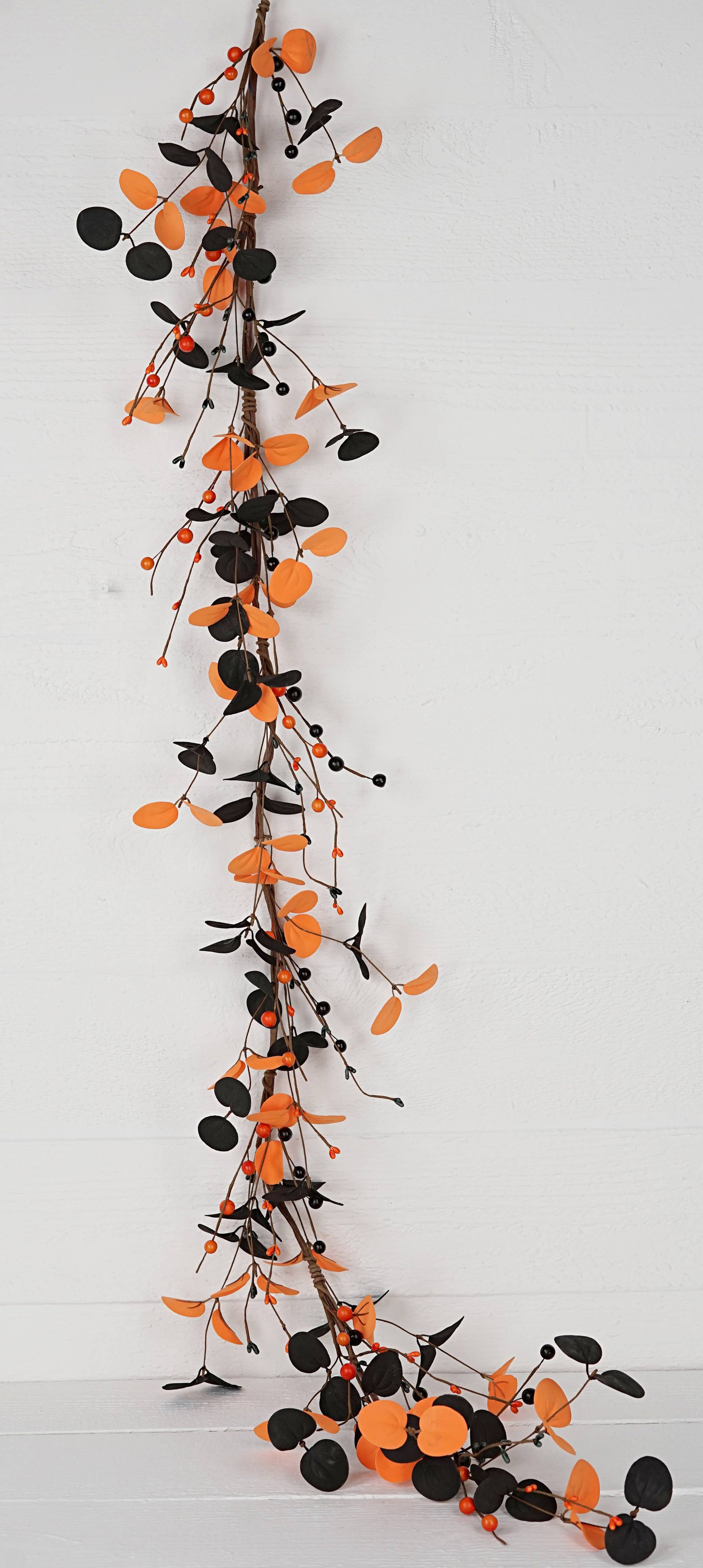Decorative garland with black and orange berries on a white background