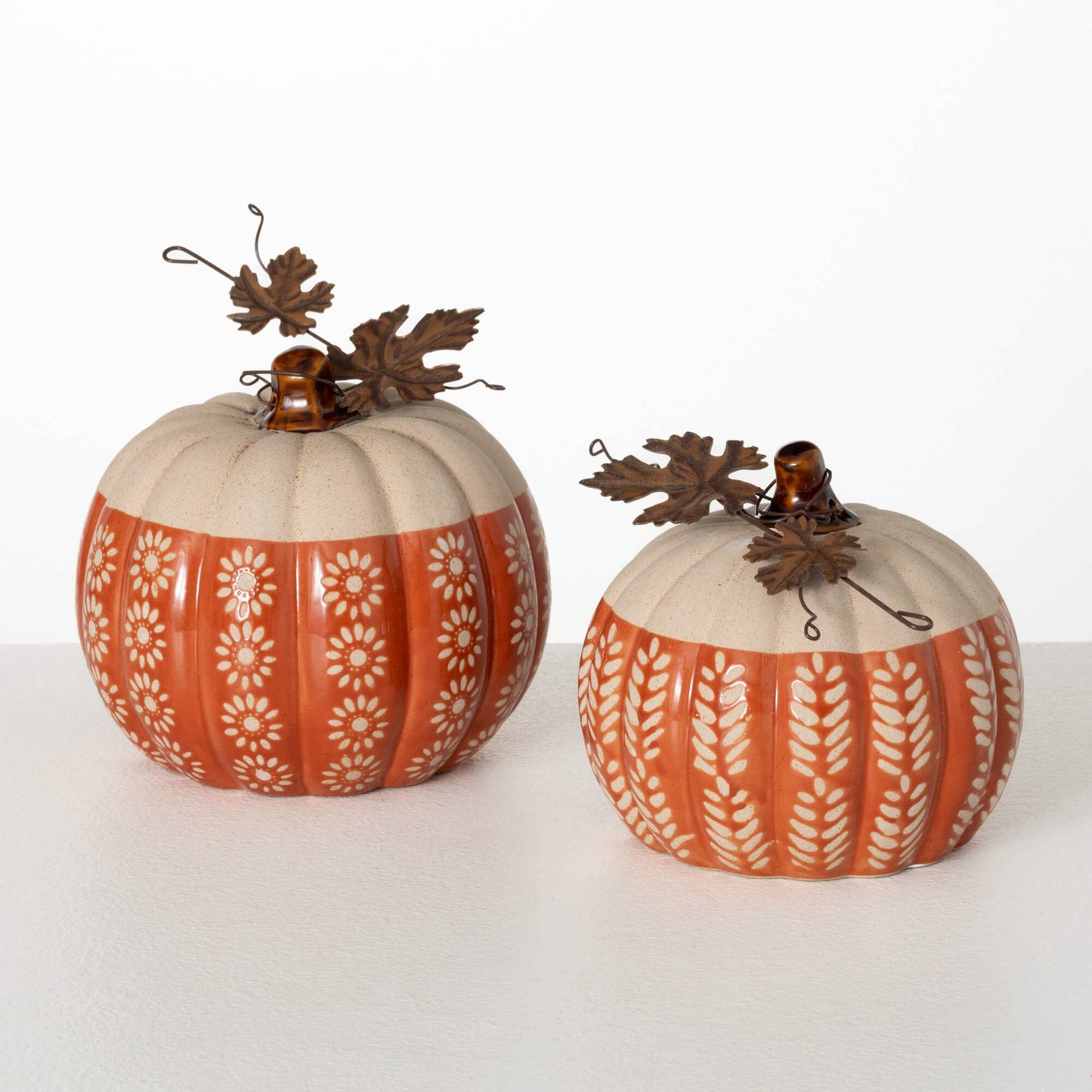 Two decorative pumpkins with patterns on a white background