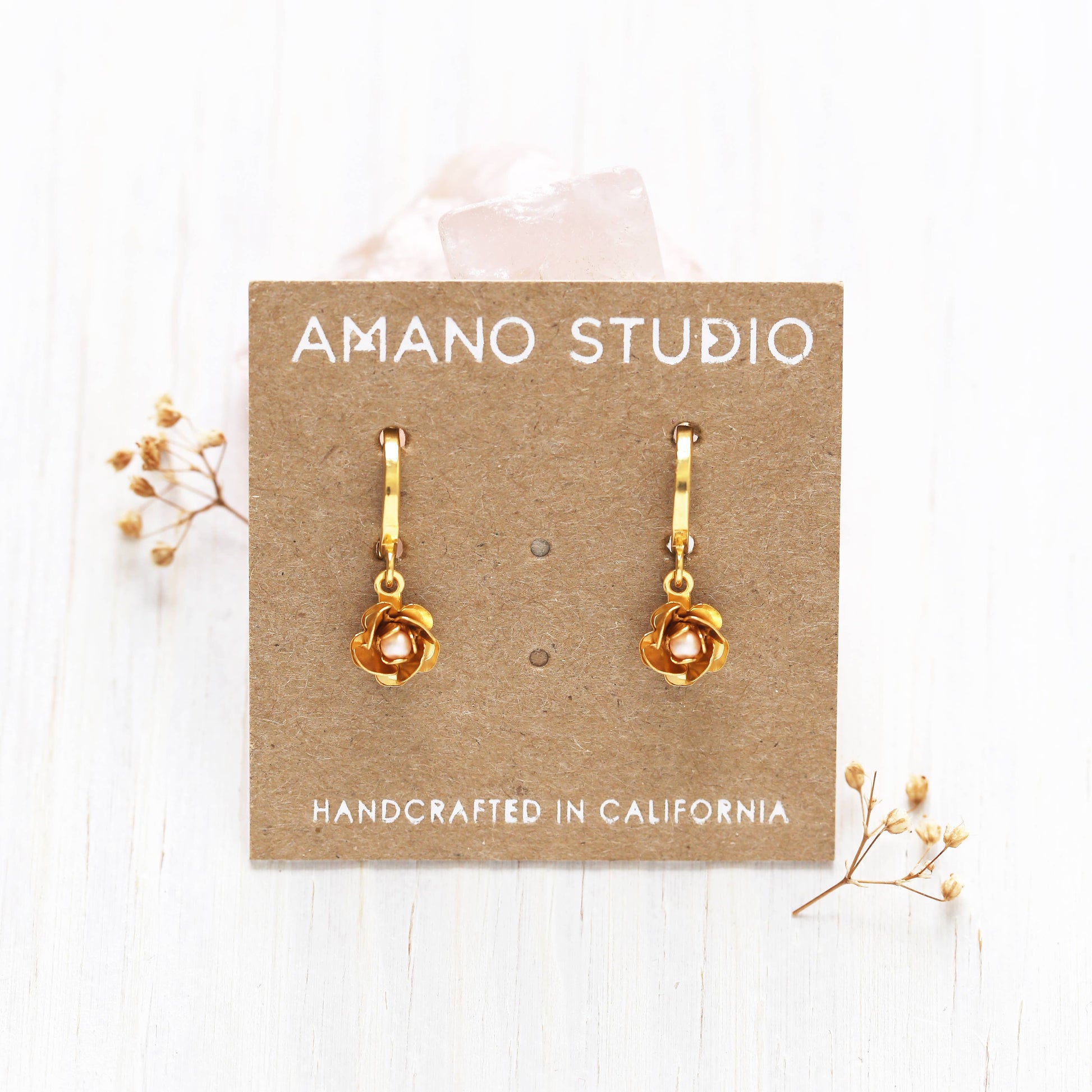 gold rose drop earrings on brown card
