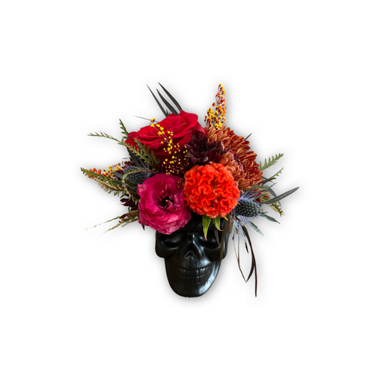 Floral arrangement in a black skull container for Las Vegas delivery