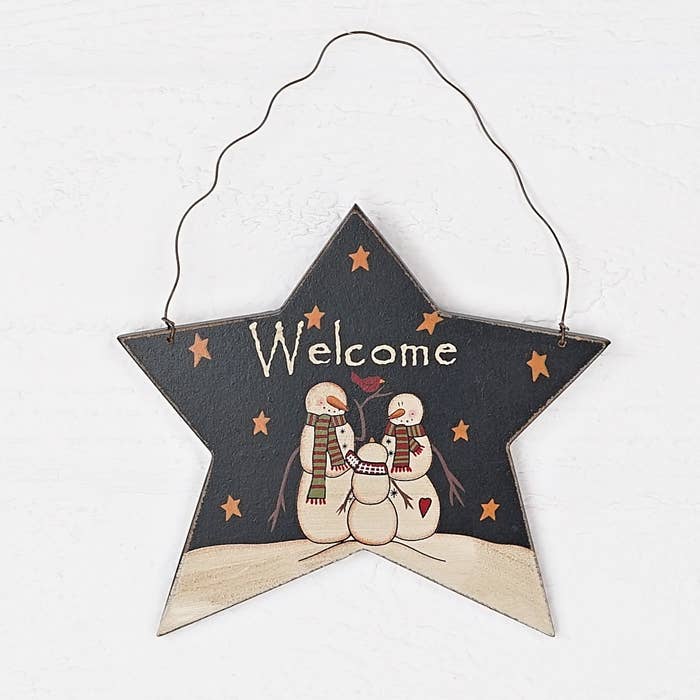 Star-shaped wooden sign with snowmen and 'Welcome' text on a white background