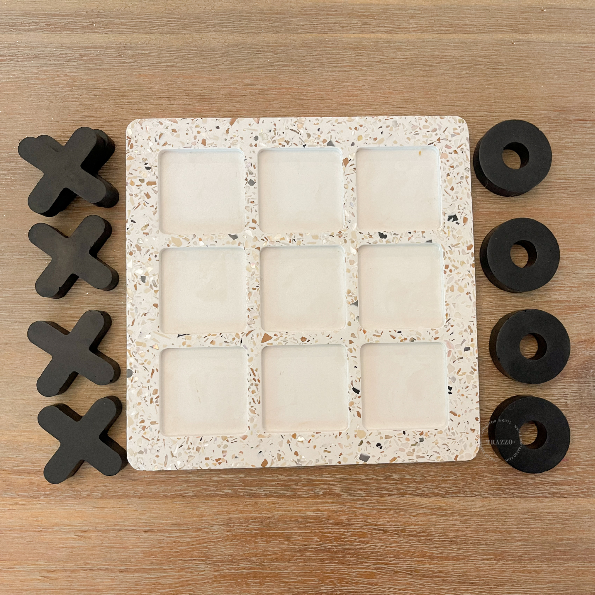 white terrazzo game board and black xoxo game pieces for tic-tac-toe set